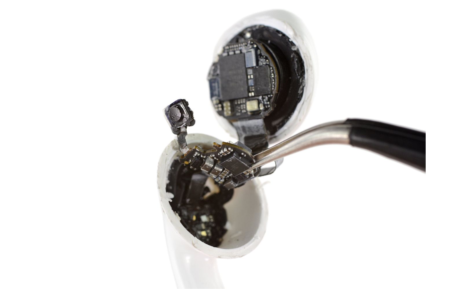 Detalhe técnico interno de AirPods com bateria e circuito